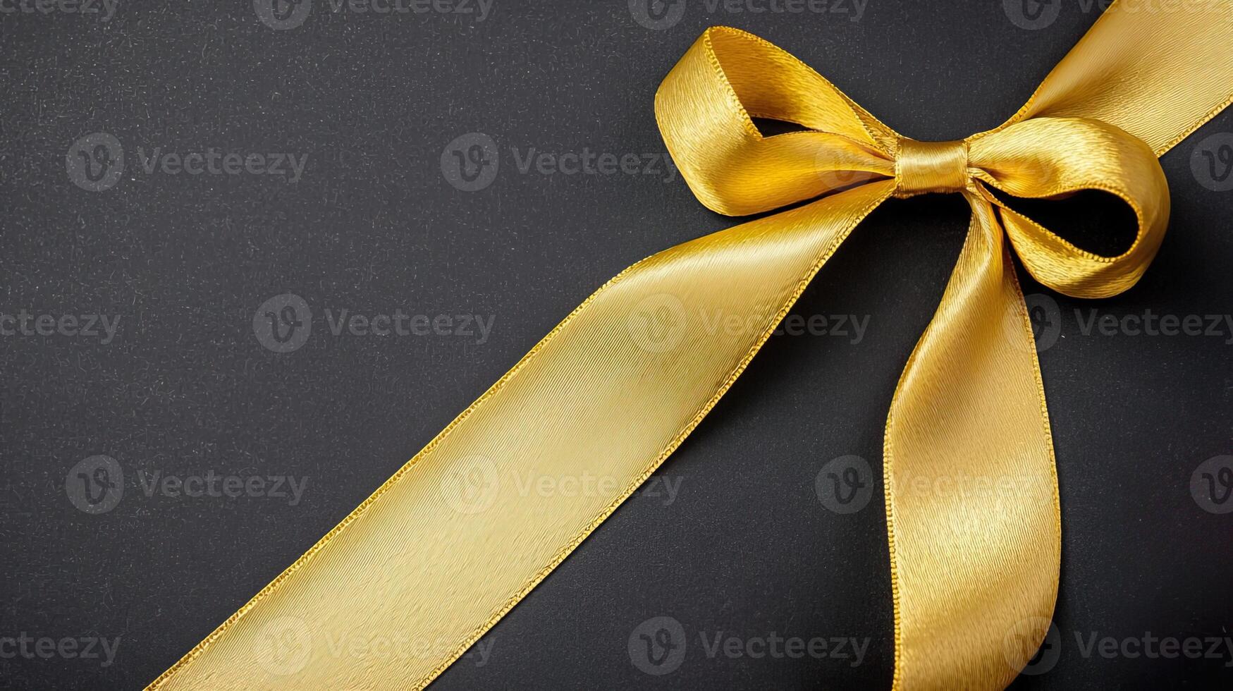 Golden satin ribbon on a black background, providing an elegant touch for presentations. photo