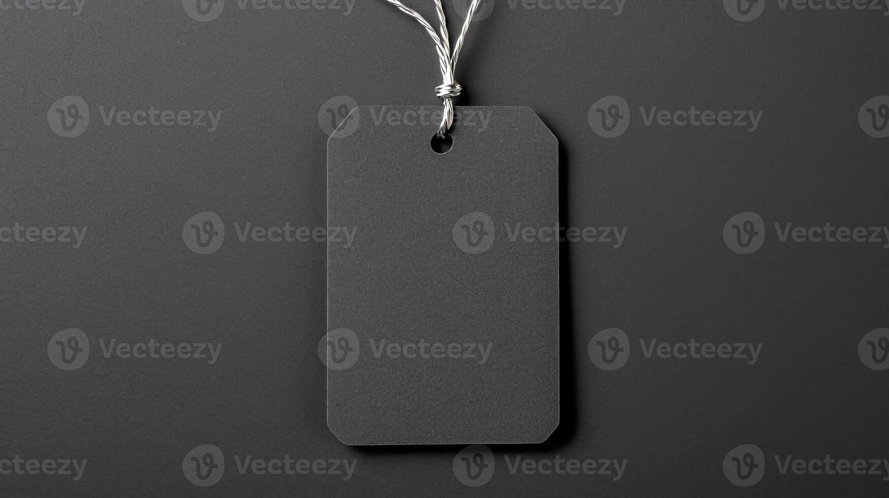 Black recycled price card with silver elastic band on a black background. photo