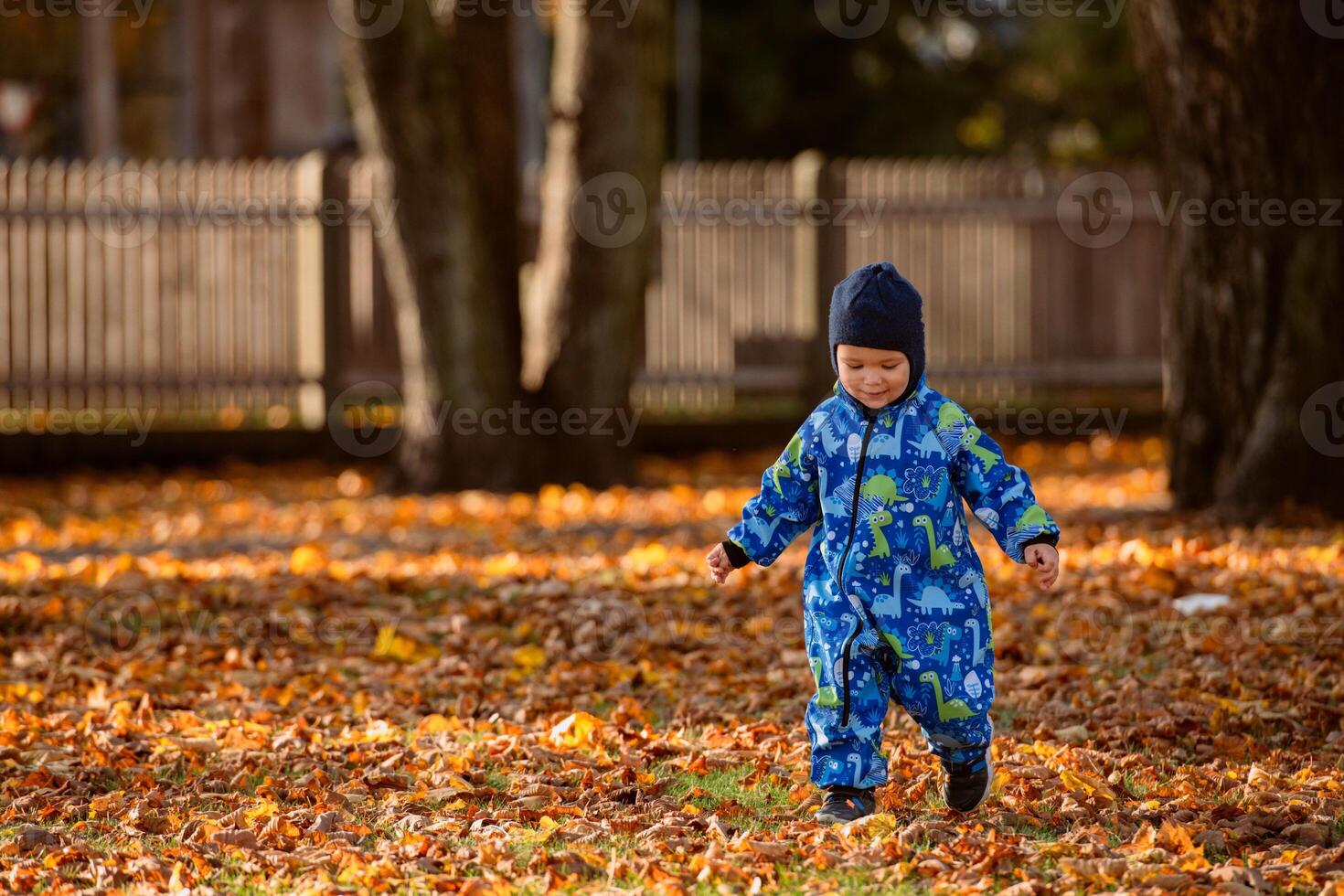 A joyful little boy in his winter coat and hat plays happily in the park, surrounded by the love and warmth of his smiling parents photo
