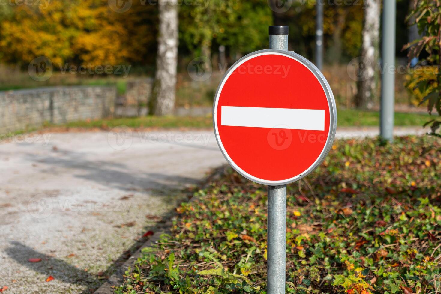 No entry sign near a path in a park during autumn season photo