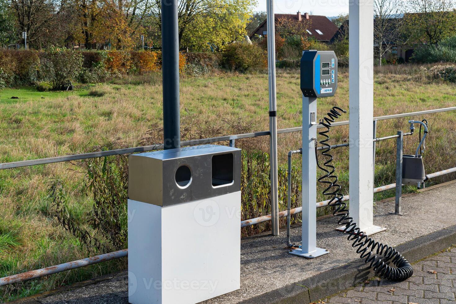 Self-service car wash station with air pump and trash bin photo