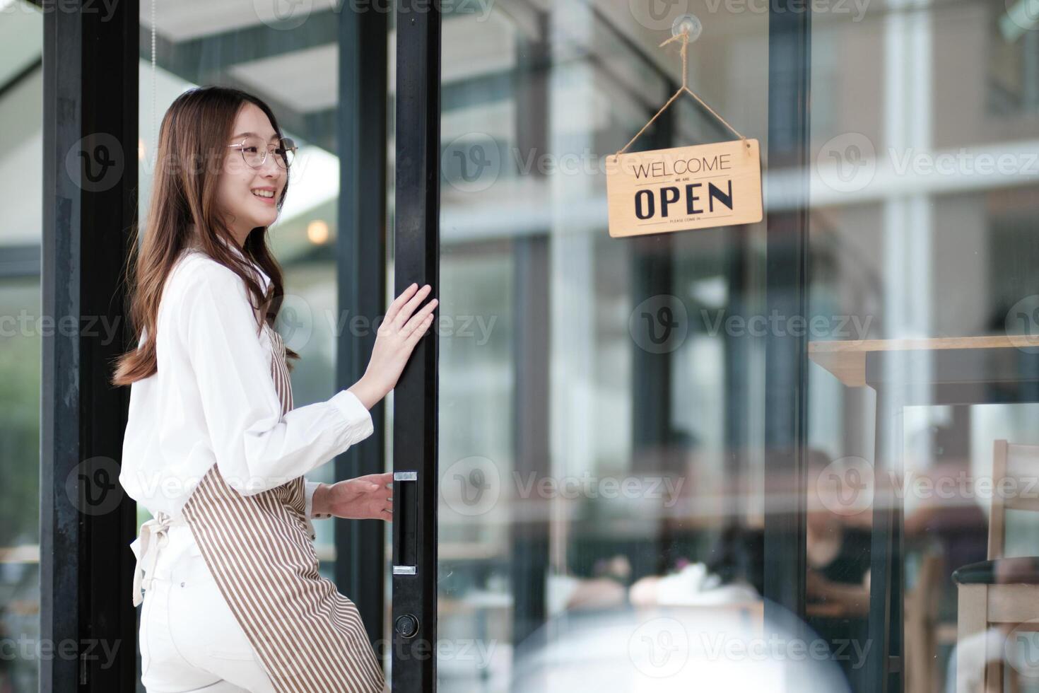 Cafe staff or owner opening the shop door, inviting customers with a friendly to start the day. photo