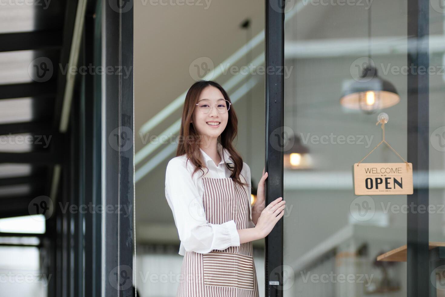 Cafe staff or owner opening the shop door, inviting customers with a friendly to start the day. photo