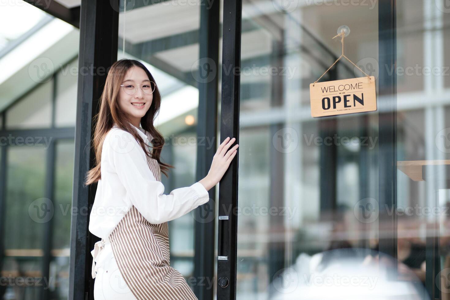 Cafe staff or owner opening the shop door, inviting customers with a friendly to start the day. photo