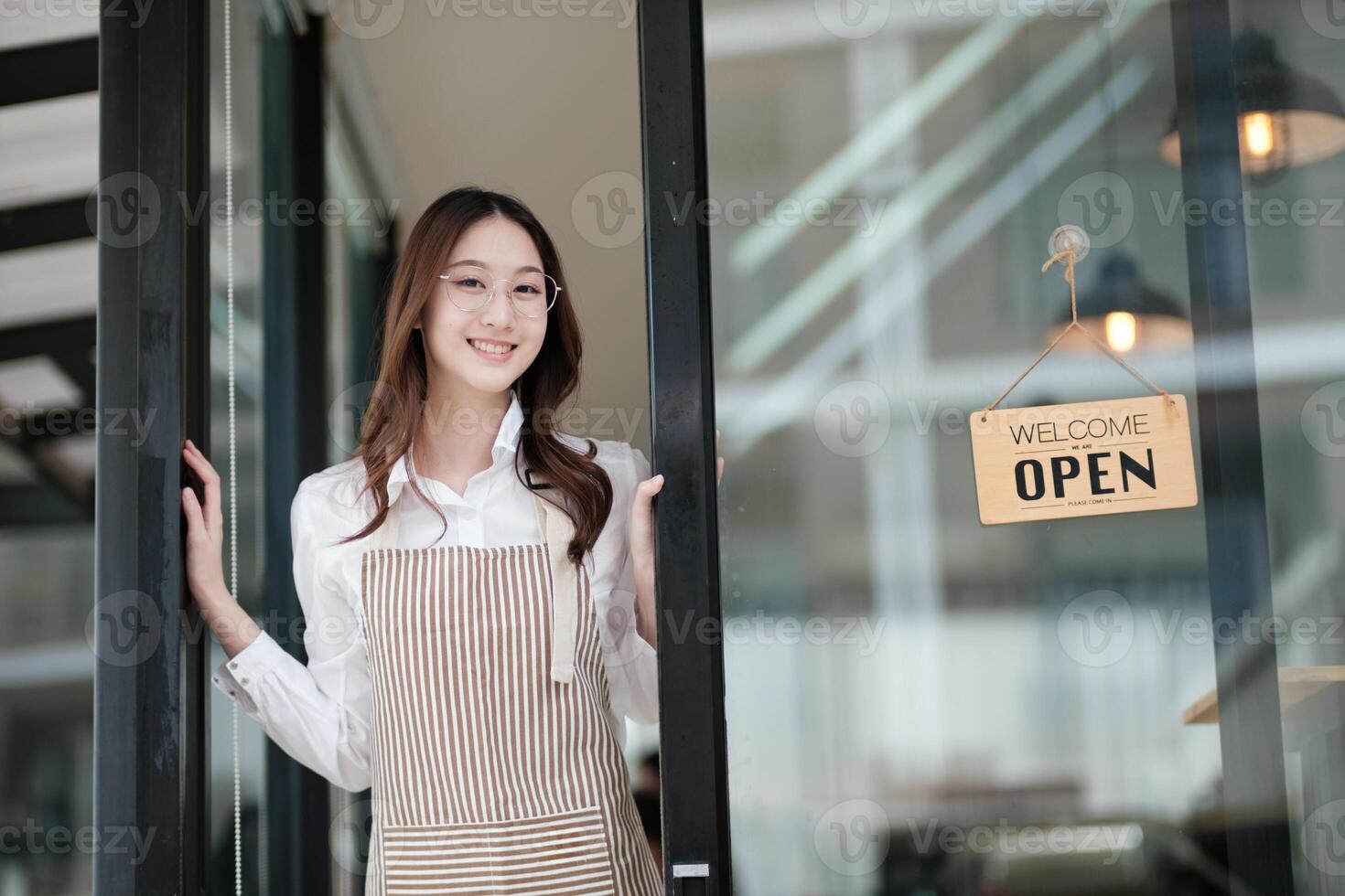 Cafe staff or owner opening the shop door, inviting customers with a friendly to start the day. photo