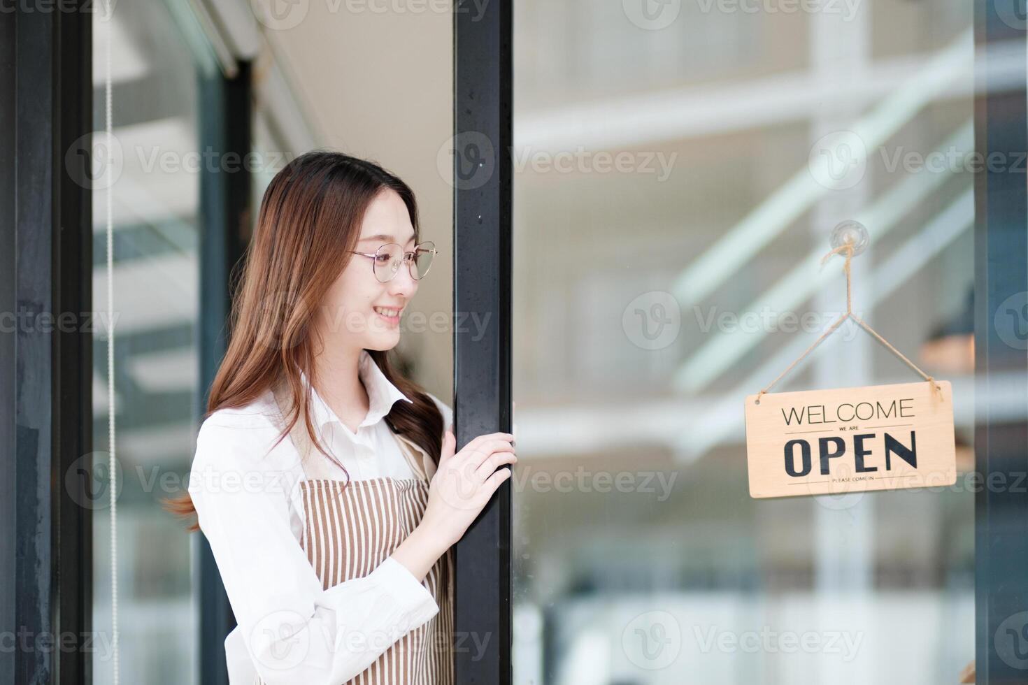 Cafe staff or owner opening the shop door, inviting customers with a friendly to start the day. photo