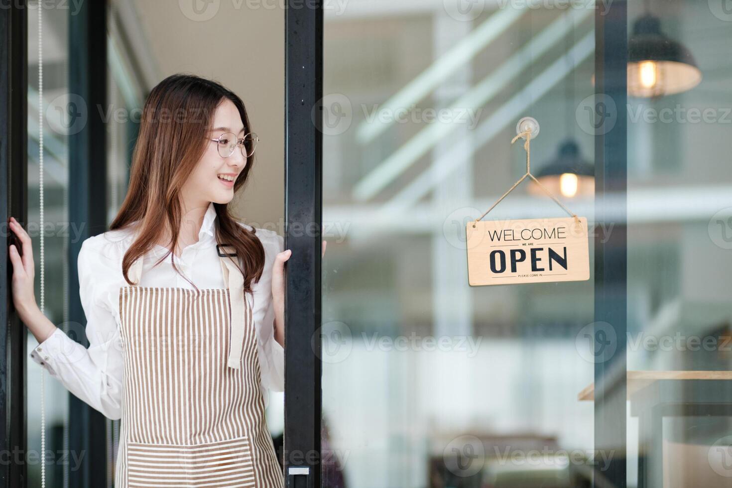 Cafe staff or owner opening the shop door, inviting customers with a friendly to start the day. photo