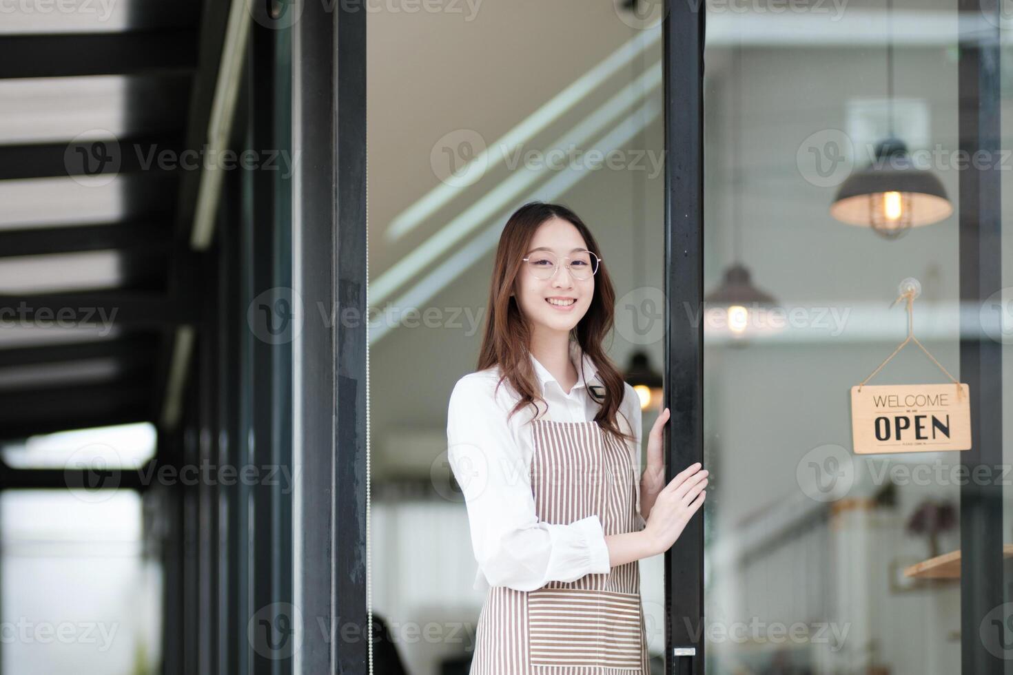 Cafe staff or owner opening the shop door, inviting customers with a friendly to start the day. photo
