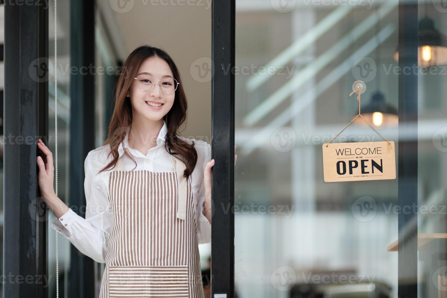 Cafe staff or owner opening the shop door, inviting customers with a friendly to start the day. photo