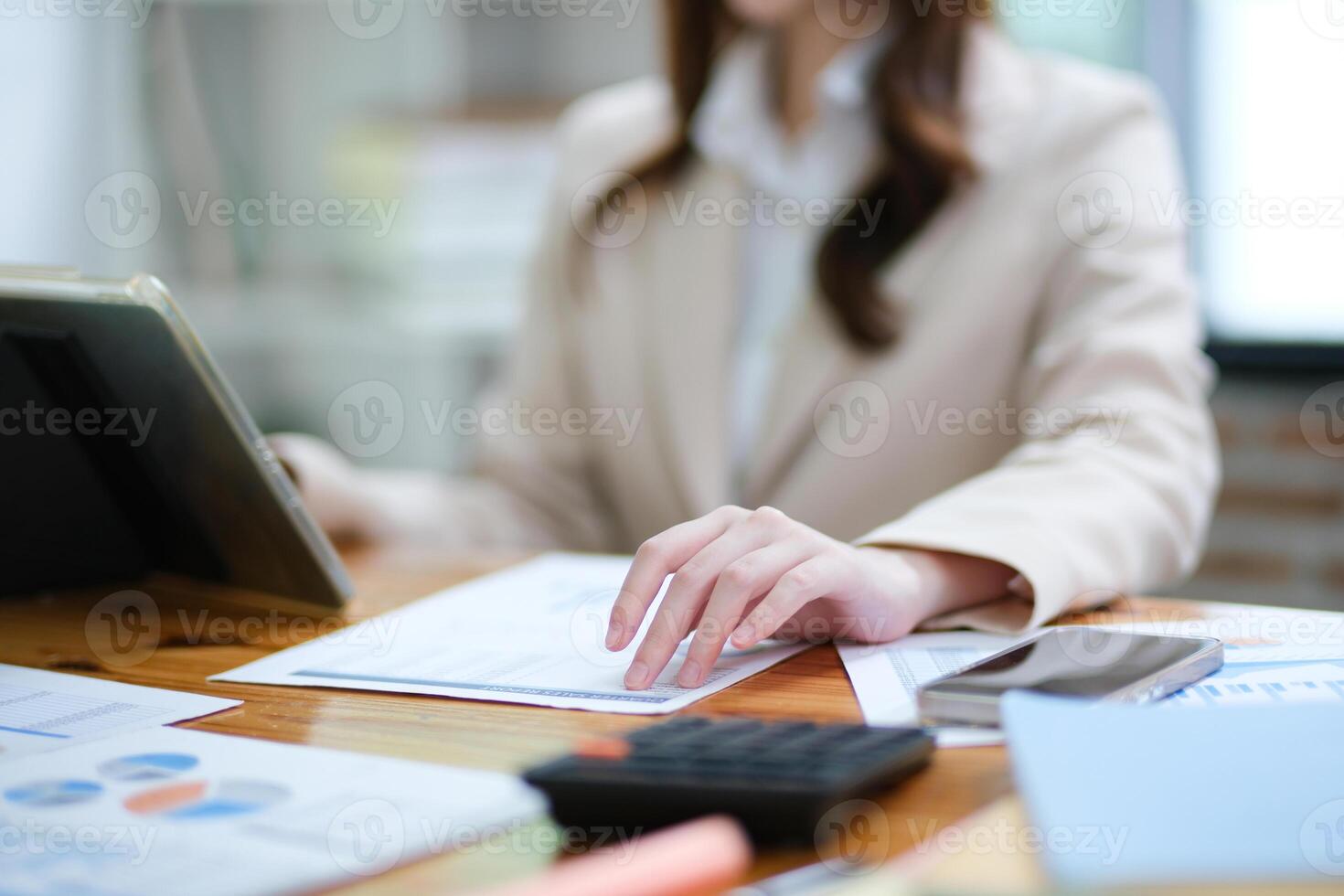 Businesswoman analyzing charts and using a tablet for data review photo