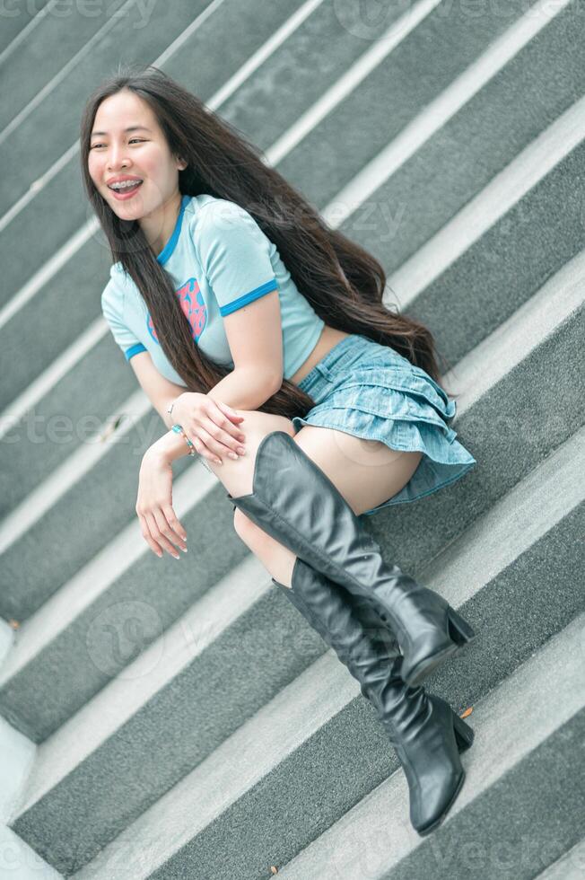 A woman sitting on some steps with her legs crossed photo
