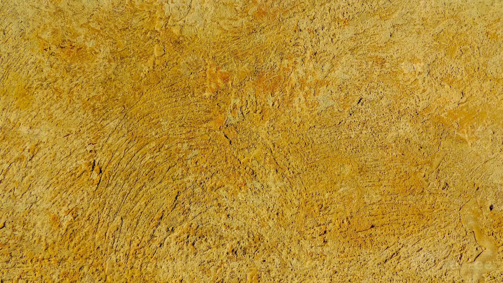 A close up of a yellow wall with some paint photo