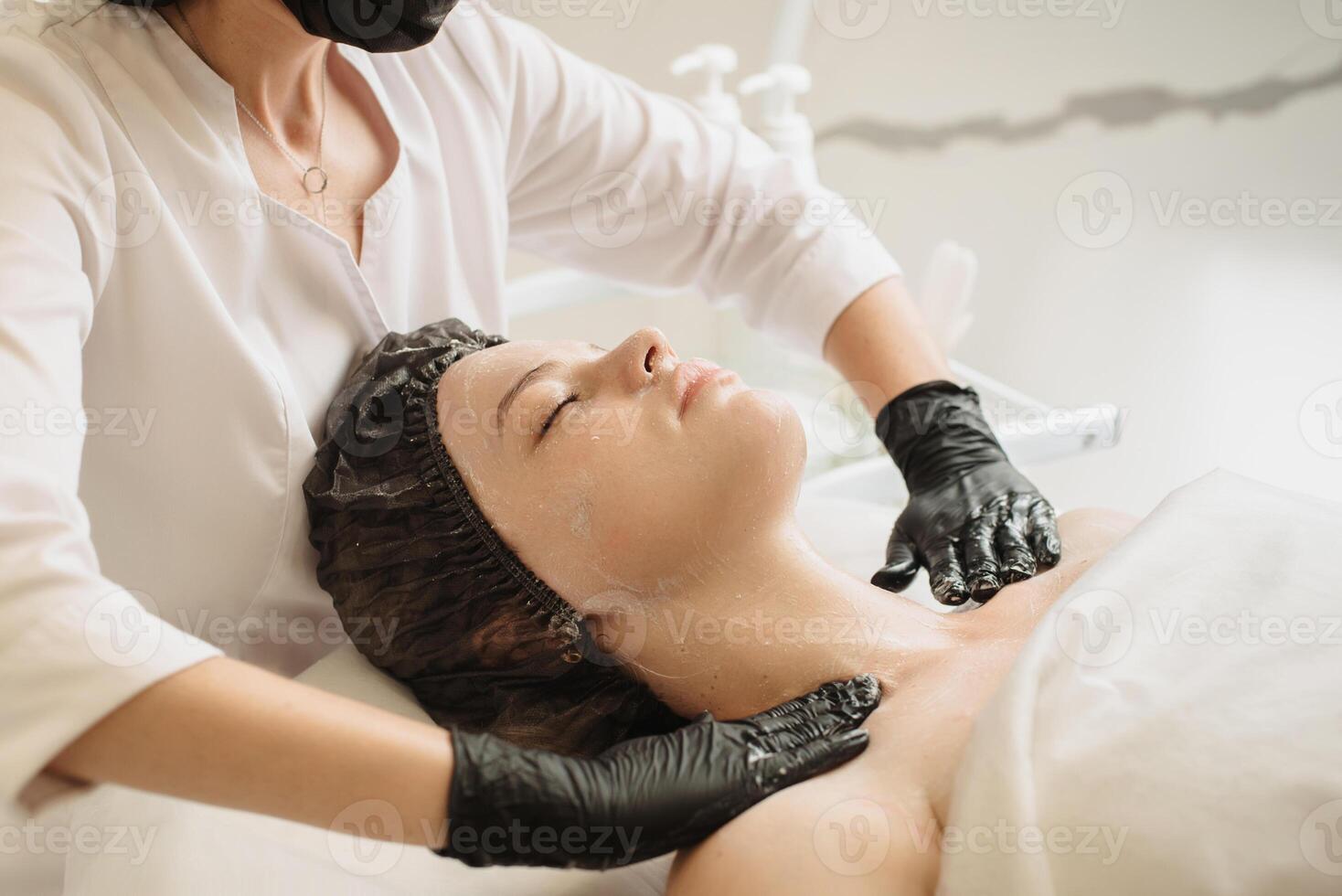 Facial peeling, spa treatments, skin care. A woman receiving facials from a cosmetologist at a spa, close-up photo