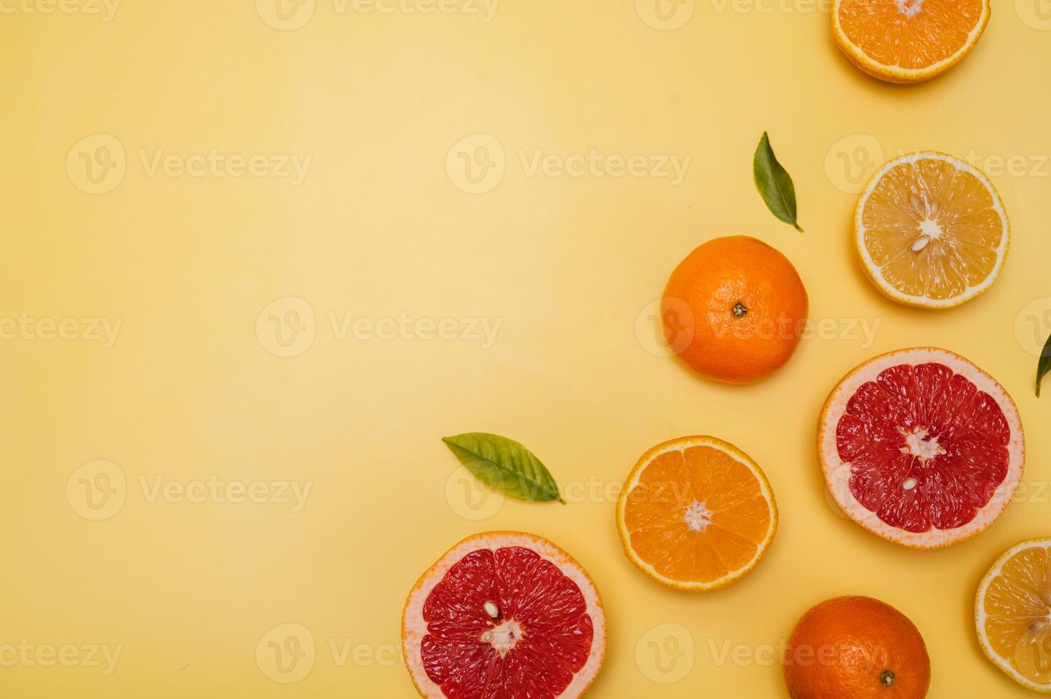 Citrus fruits on a yellow background with copyspace, fruit flatley, a summer minimalist composition with grapefruit, lemon, tangerine and orange. photo