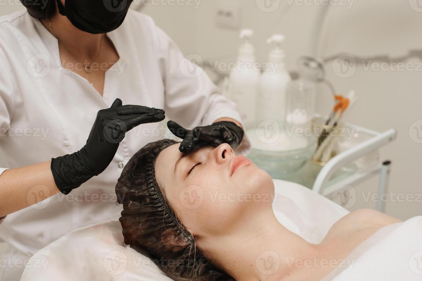 close-up of a woman's cosmetologist's hands massaging the client's facial skin. The concept of a cosmetic procedure. photo