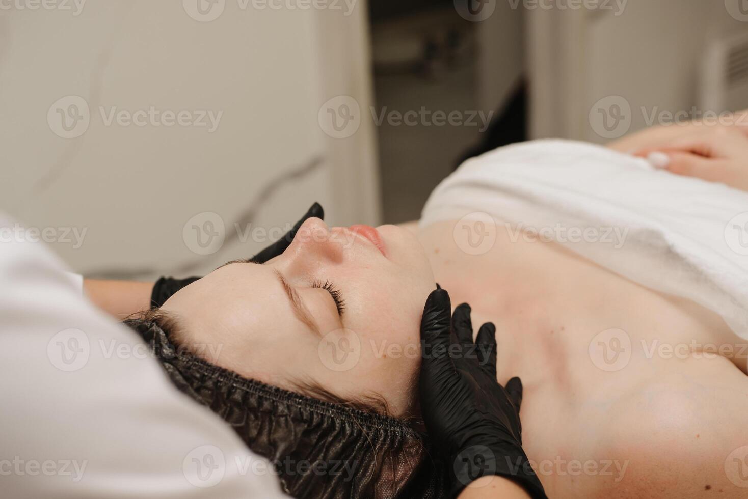 close-up of a woman's cosmetologist's hands massaging the client's facial skin. The concept of a cosmetic procedure. photo