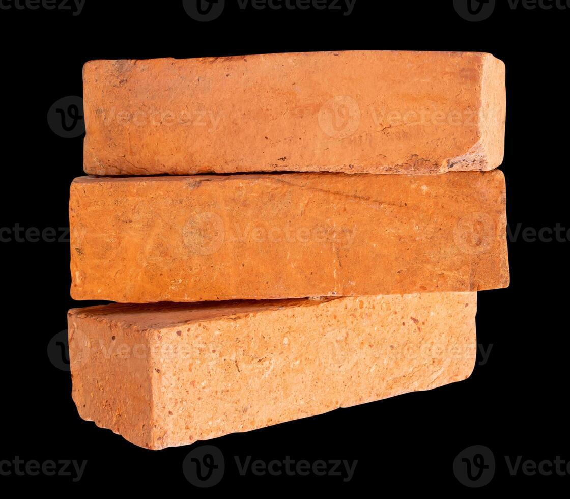 Side view of old red or orange bricks in stack isolated on black background with clipping path photo