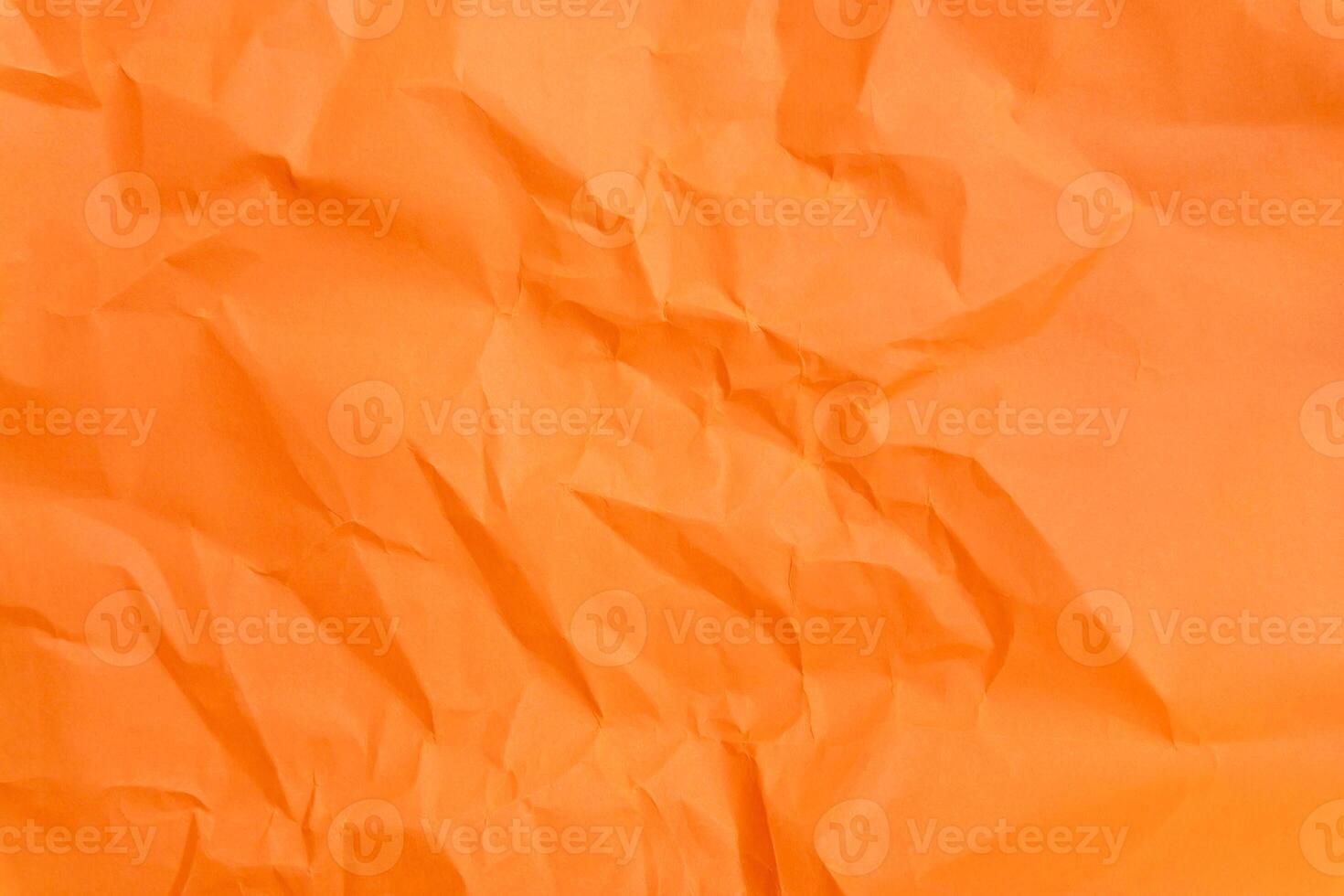 Top view and full frame of wrinkled or crumpled orange paper used as crumpled orange paper background texture. photo