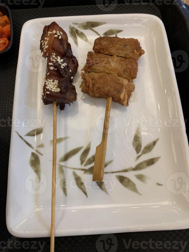 Yakitori, a traditional Japanese dish featuring skewered chicken grilled to perfection. Enjoy tender, flavorful bites with classic yakitori sauce. Ideal for street food photo
