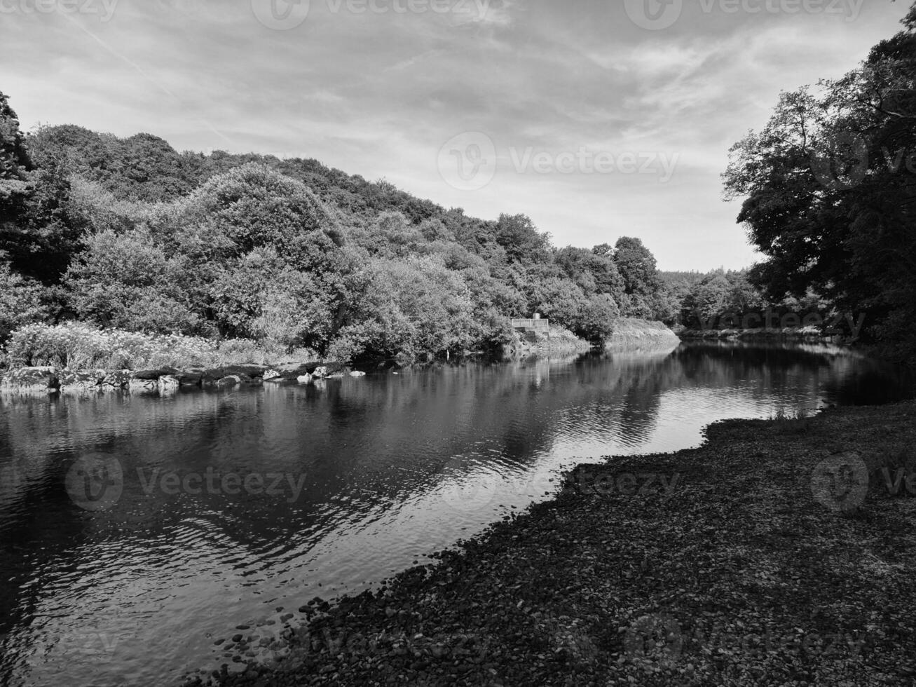 Highland Lake Surrounded by Trees and Grass Under a Cloudy Sky photo