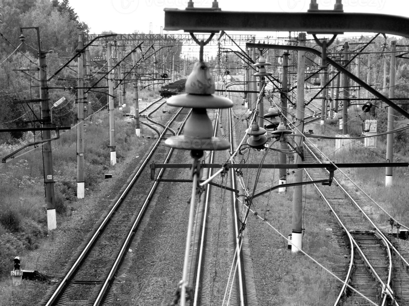 Railway Track with Overhead Power Lines and Vegetation photo