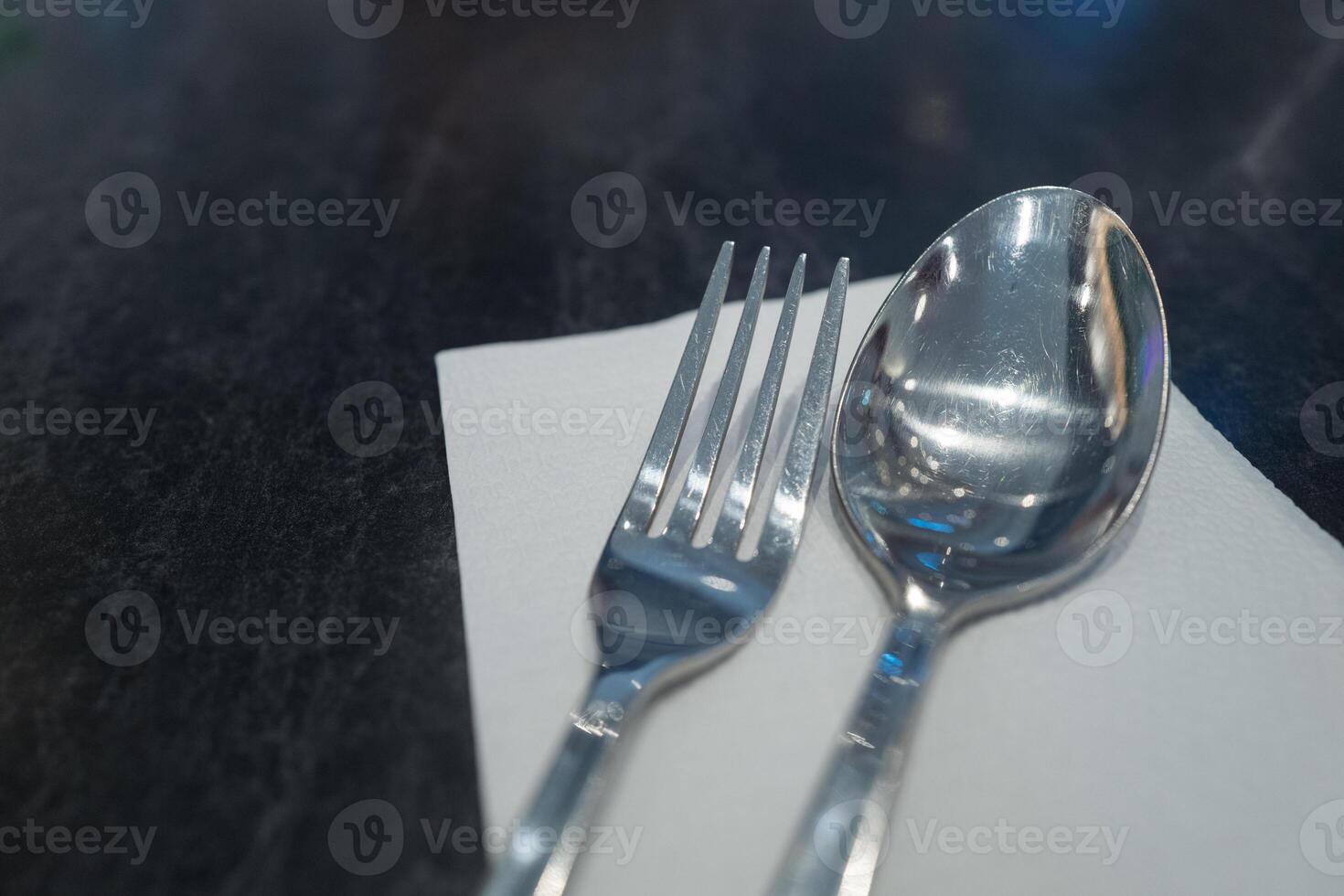 Closeup stainless steel spoon and fork on dinning table photo