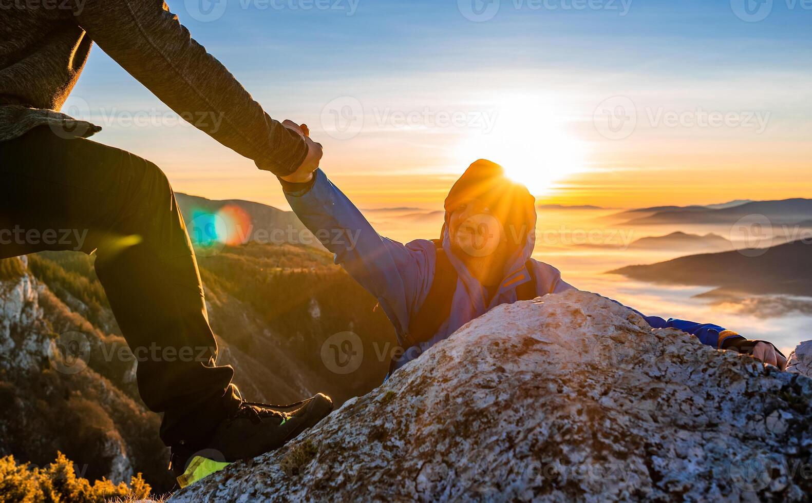 Hiking team people helping each other friend giving a helping hand while climbing up on the mountain rock adventure travel concept of support trust teamwork success. photo