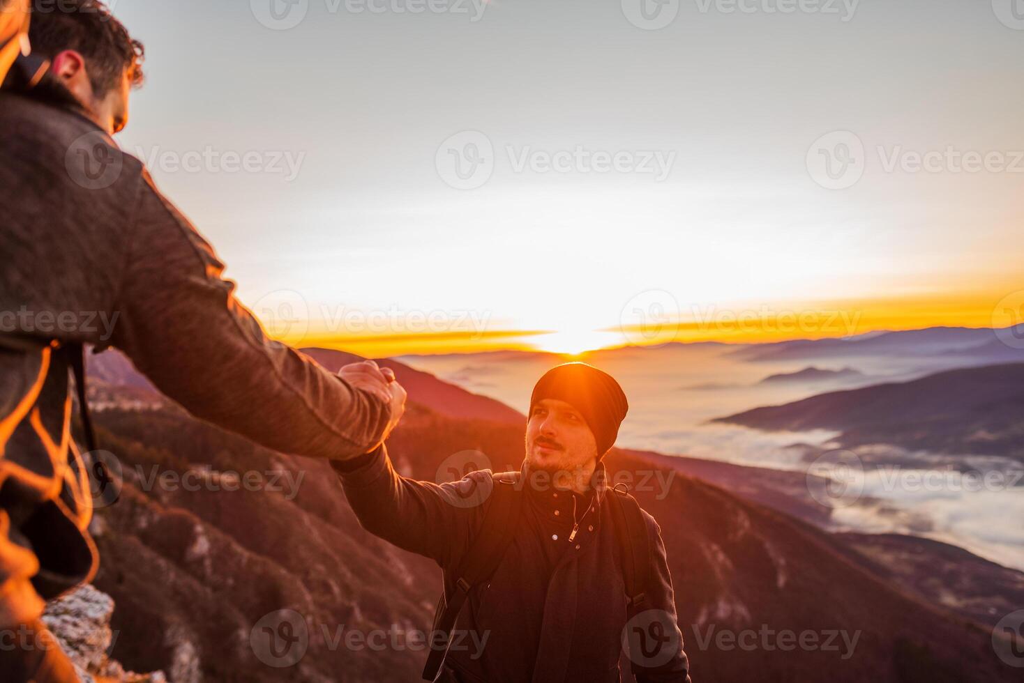 Hiking team people helping each other friend giving a helping hand while climbing up on the mountain rock adventure travel concept of friendship support trust teamwork success. photo