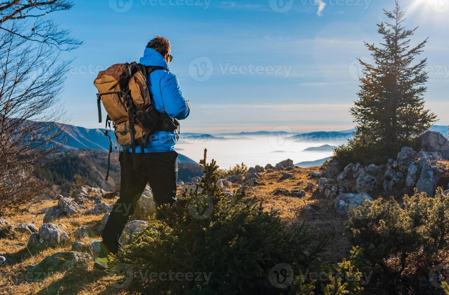 A hiker man backpacker trail hiking in mountains adventure travel active lifestyle outdoor sport. photo