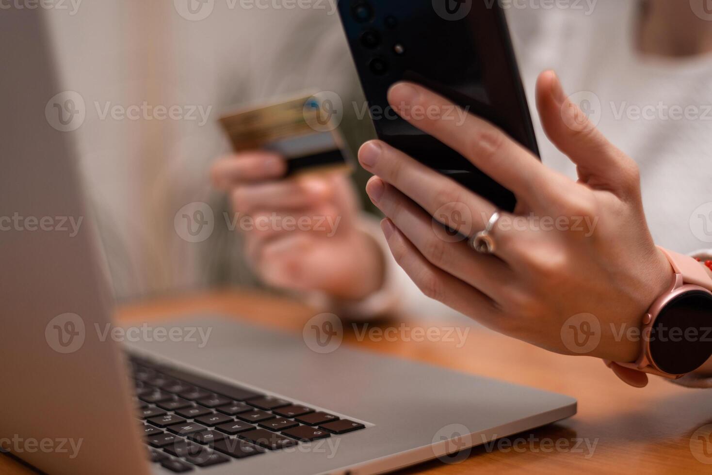 Female hands using mobile phone and holding credit card checking balance or making money transfer. Online Payment Internet Banking Concept. Woman using smartphone for online banking at home. photo