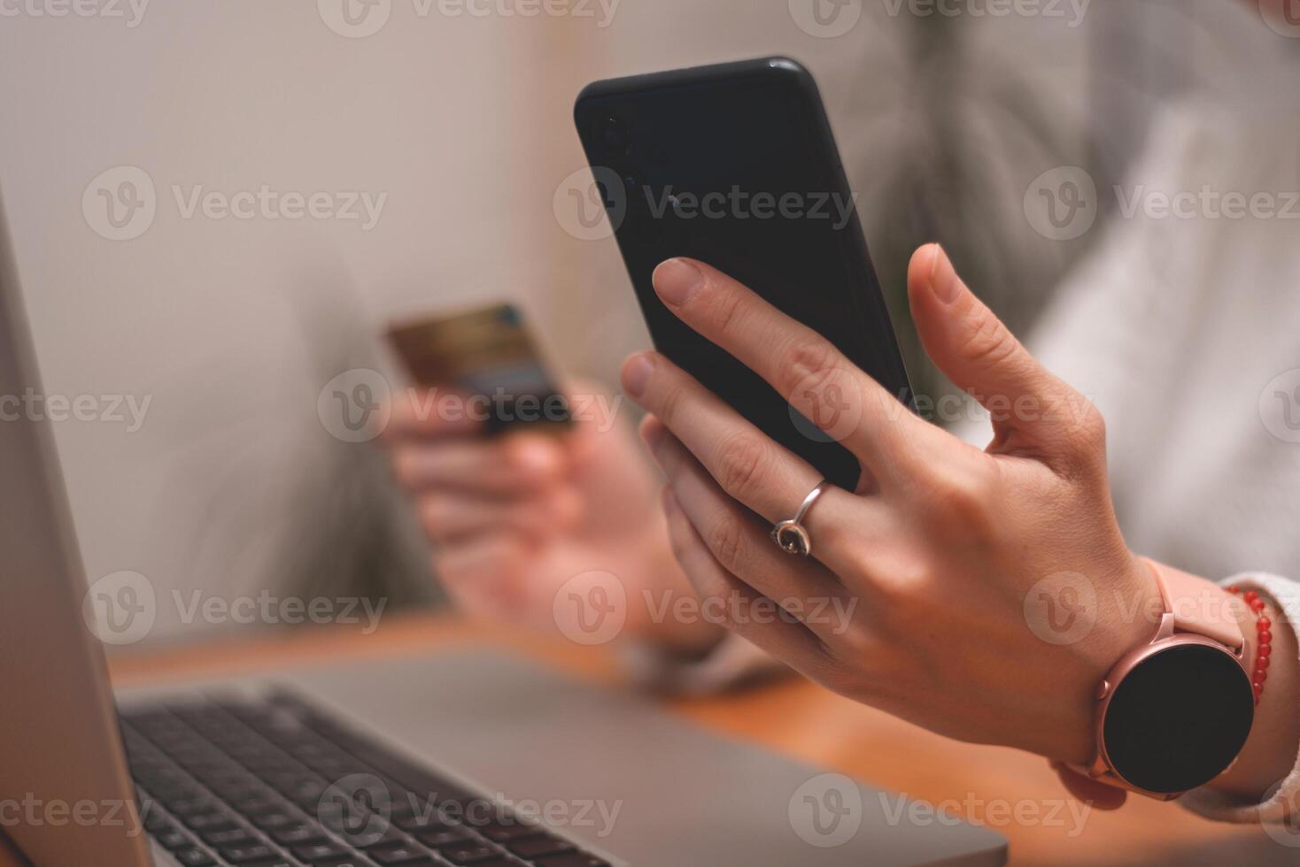 Female hands using mobile phone and holding credit card checking balance or making money transfer. Online Payment Internet Banking Concept. Woman using smartphone for online banking at home. photo
