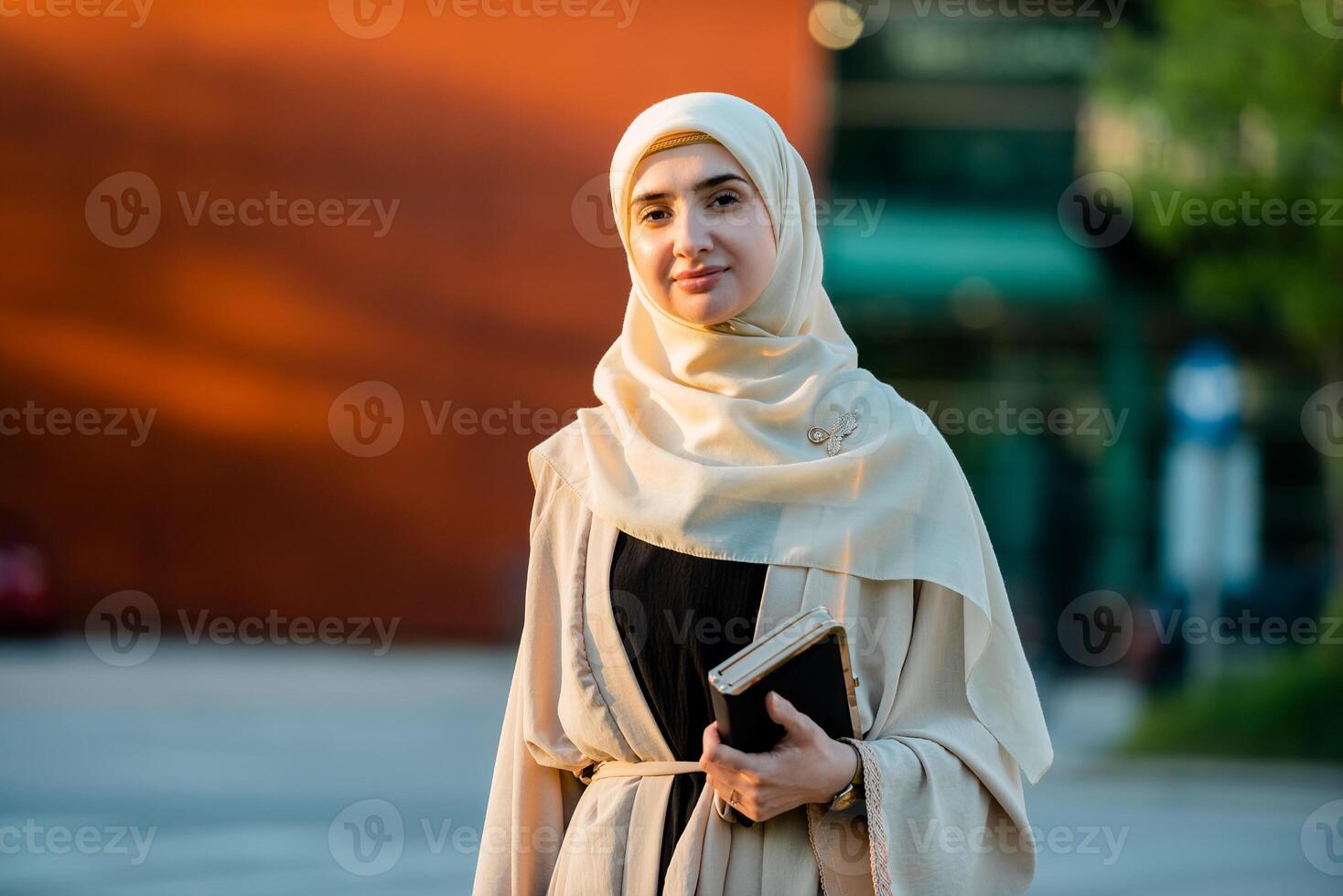 Portrait of a confident Muslim business woman in hijab with the city street in the background. photo
