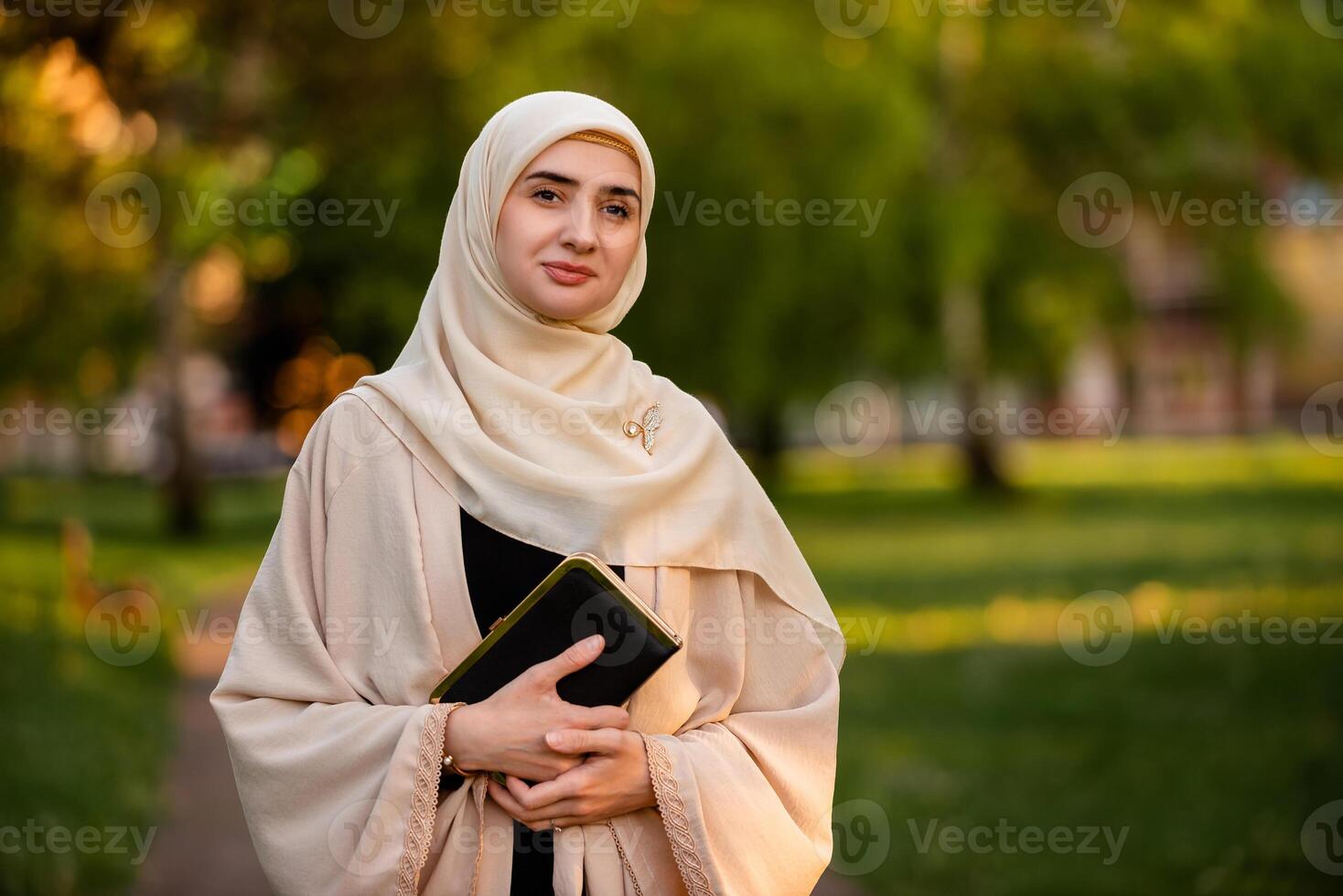 Portrait of a young Muslim woman in hijab outside. photo