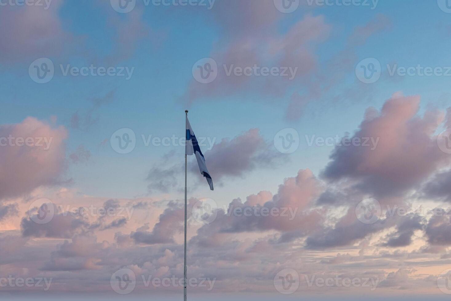 Finnish Flag Waving Against Pastel Sky in Helsinki, Finland photo