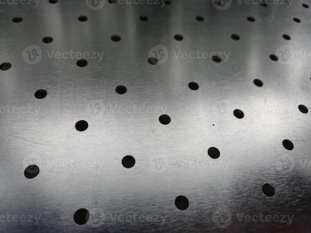 Metal surface with holes abstract background photo