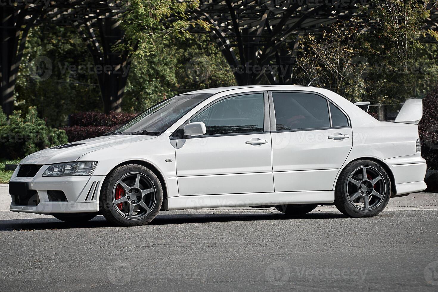 White car on a street background. Modern city sport car with a spoiler wallpaper photo
