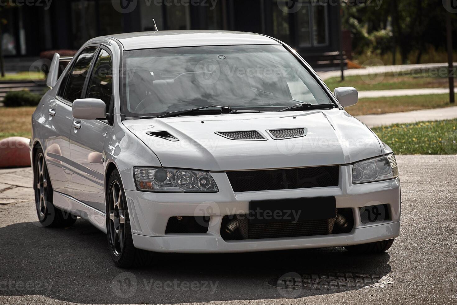White car on a street background. Modern city sport car with a spoiler wallpaper photo