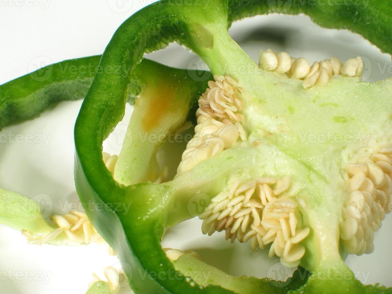 Freshly Picked Edible Flower IngreSliced Green Bell Pepper with Seeds on White Background photo