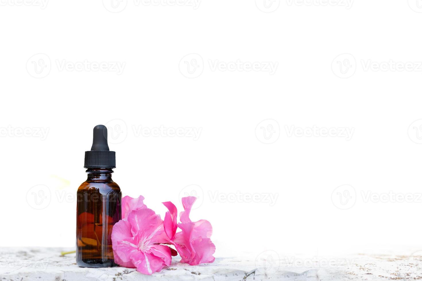 Brown dropper bottle with pink flowers on white background photo