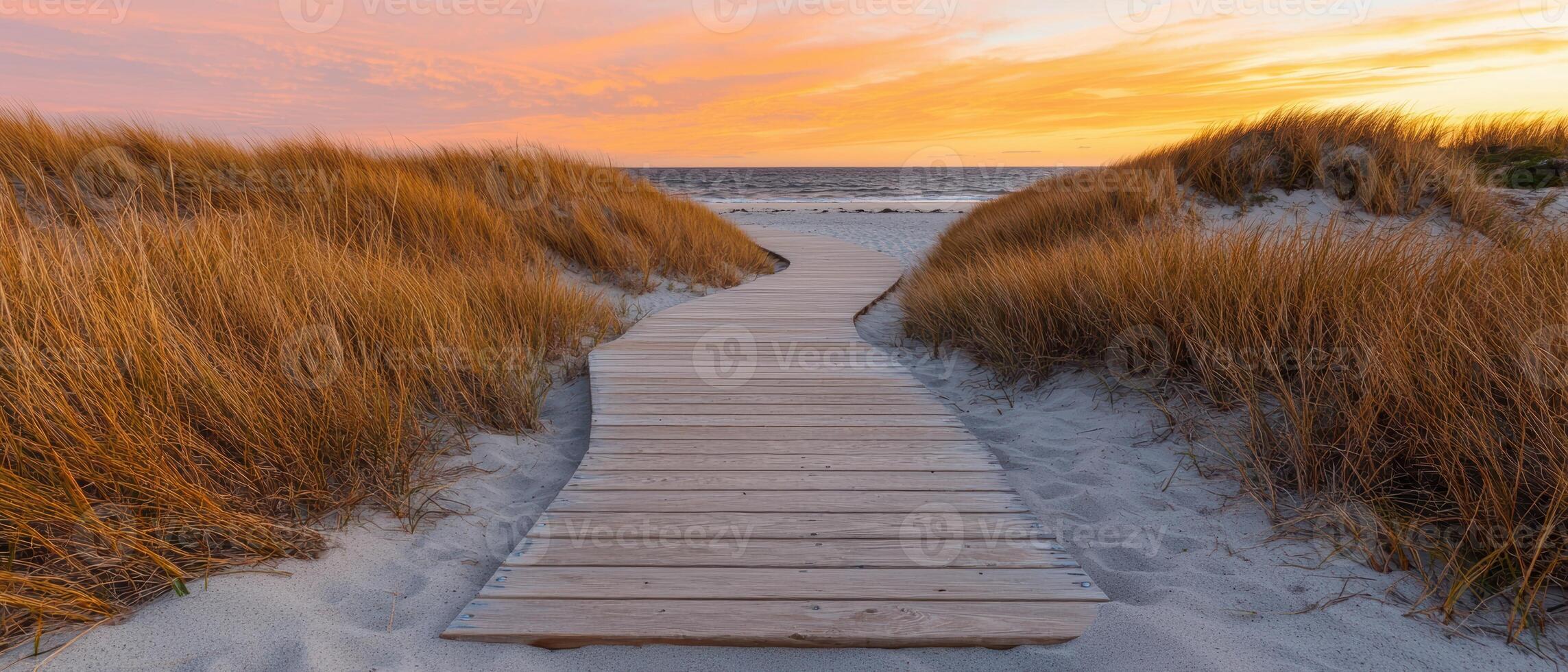 Wooden walkway leading to the beach at sunset photo