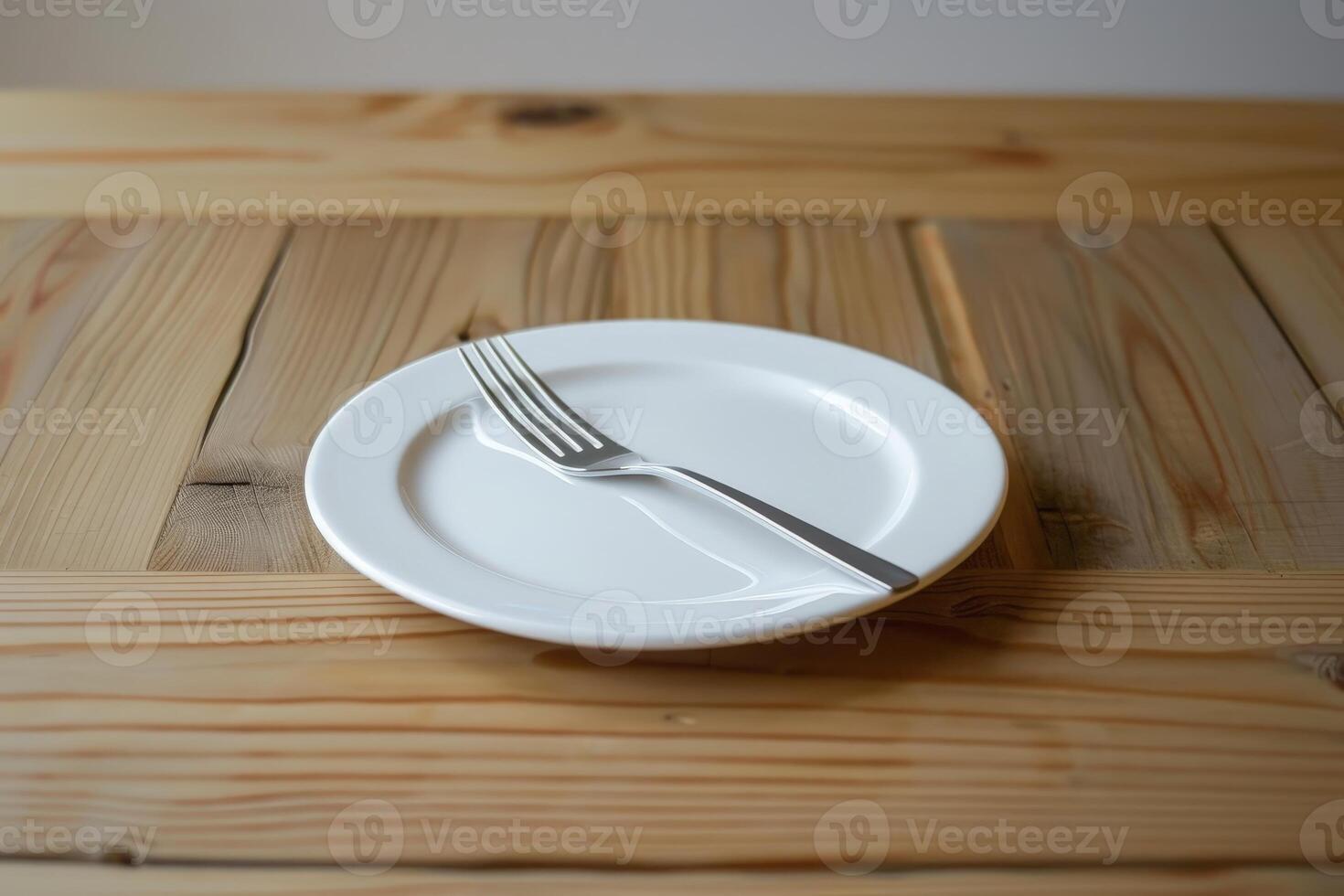 empty white plate and fork on wooden table photo