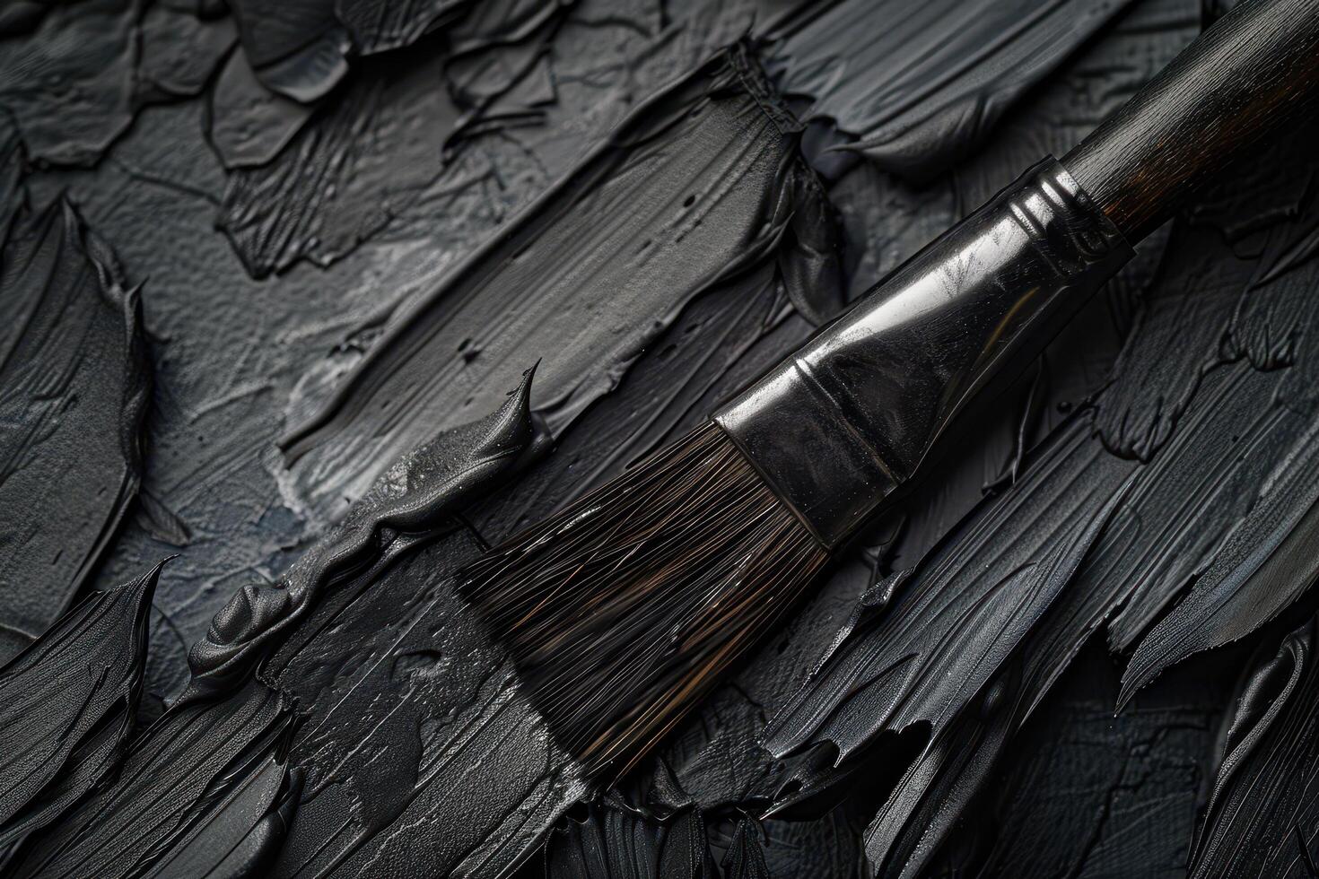 Closeup of a black paintbrush on a dark textured background photo