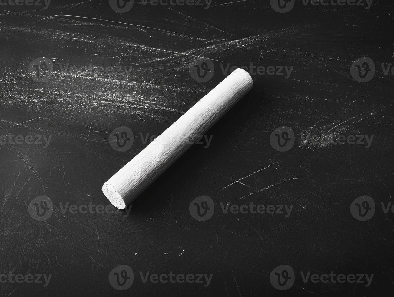 Closeup of a white chalk stick on a black background photo