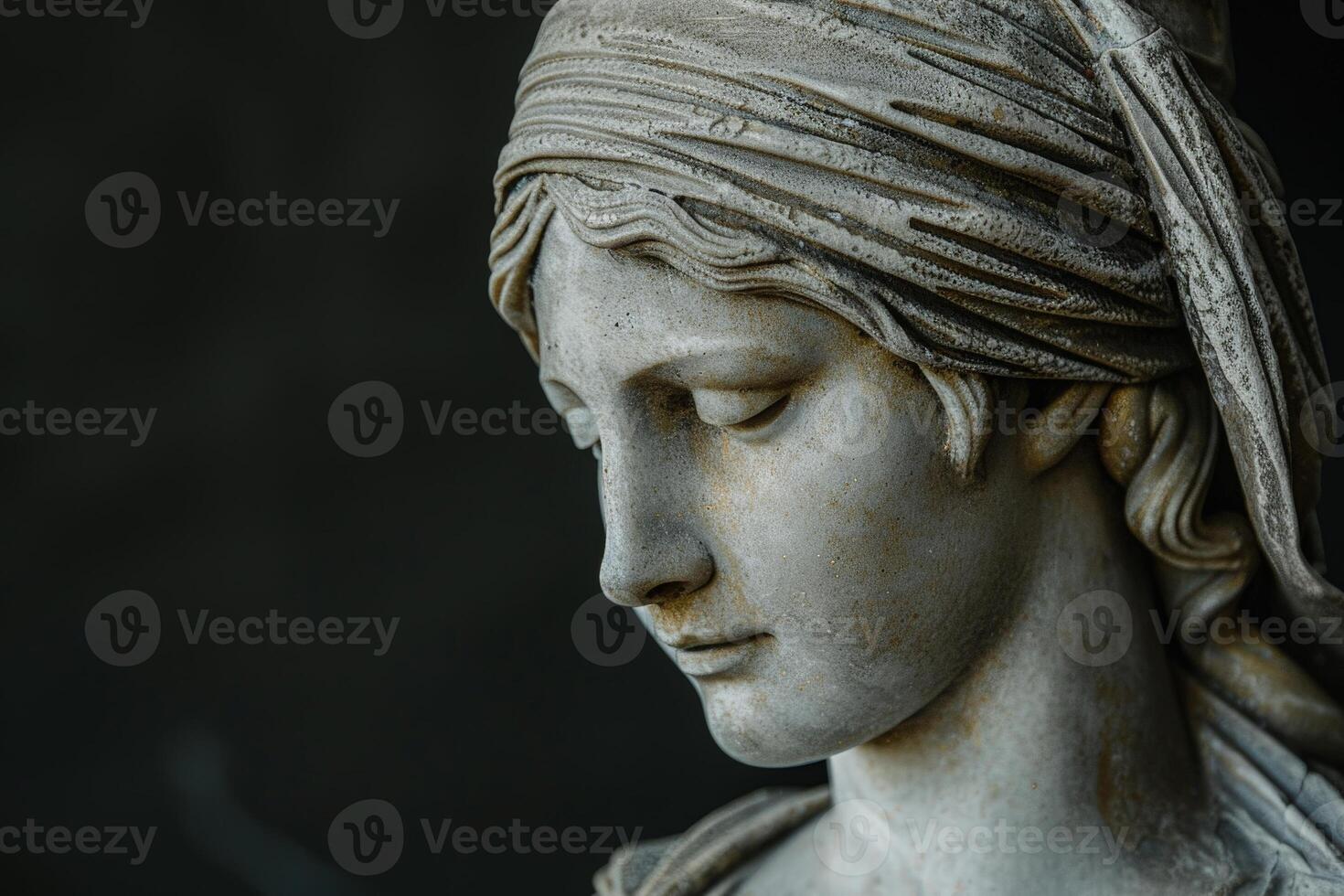 Weathered stone statue of a woman with draped clothing photo