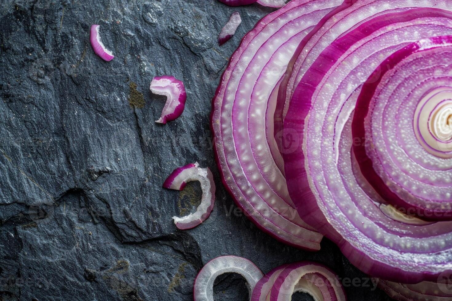 Sliced red onion on dark stone background photo