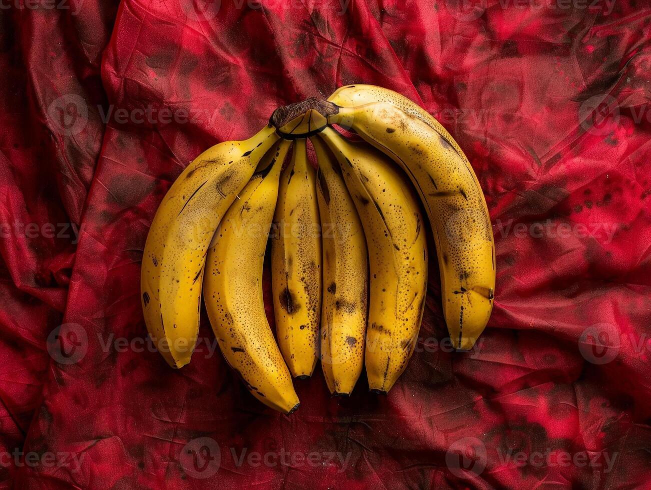 Ripe yellow bananas on red fabric background photo
