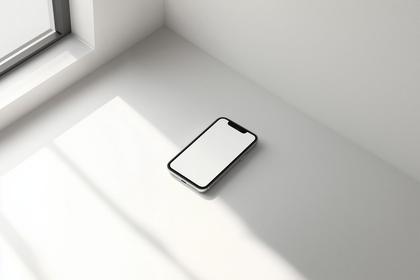 A minimalist smartphone rests on a white surface bathed in soft sunlight, showcasing sleek design and modern technology photo
