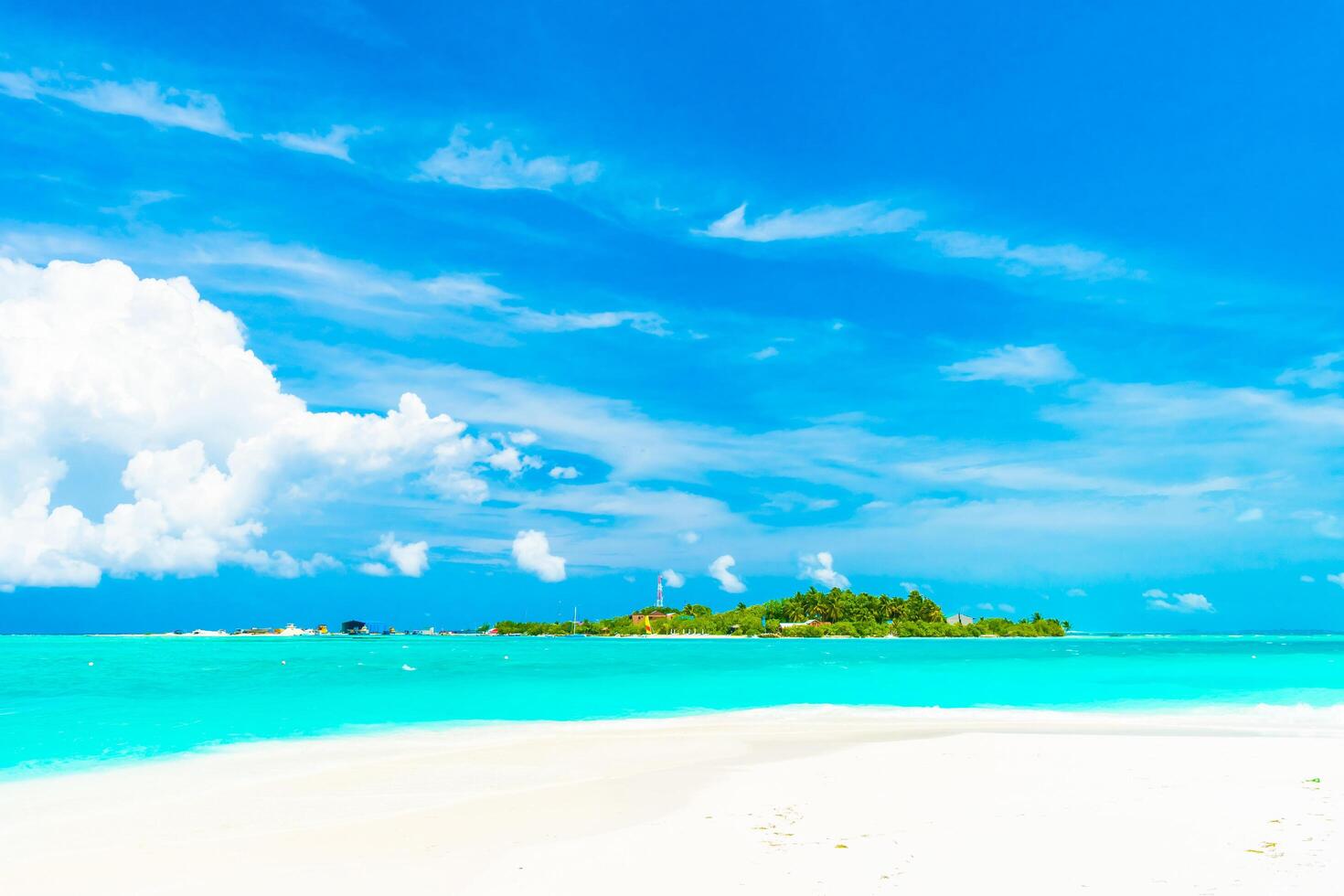 A beach with a white sand beach and a blue sky photo
