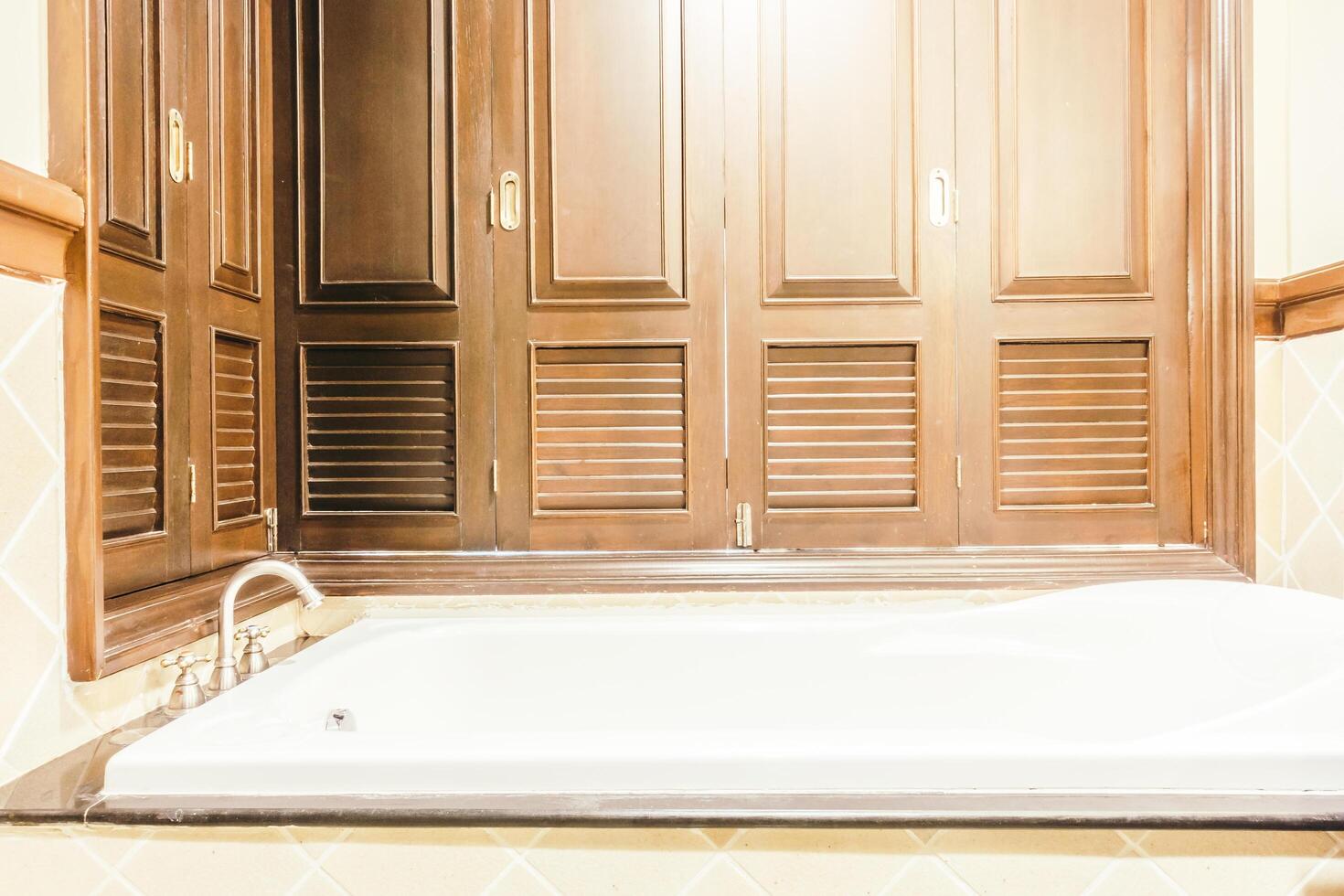 A bathroom with a tub and a window photo