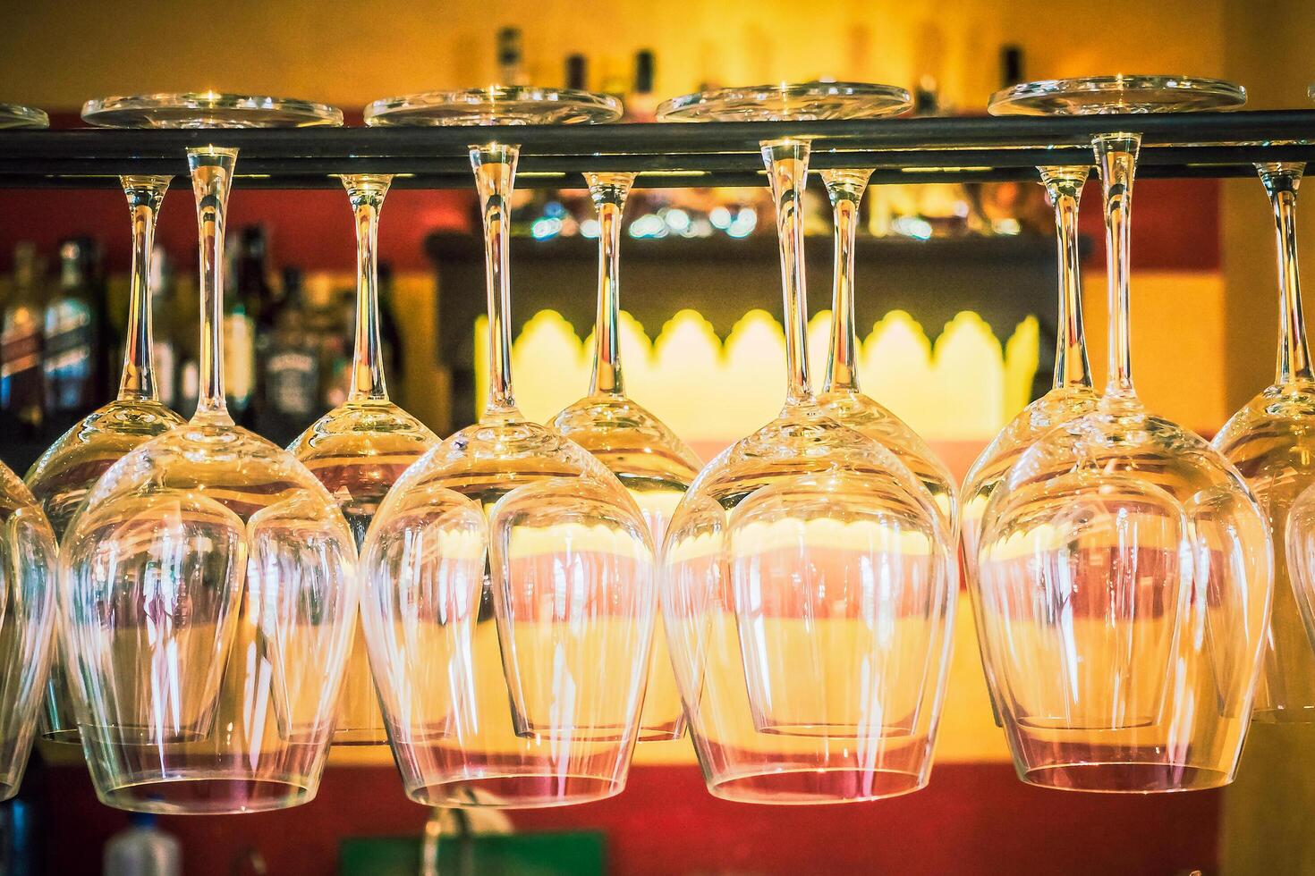 A bar with a rack of wine glasses photo